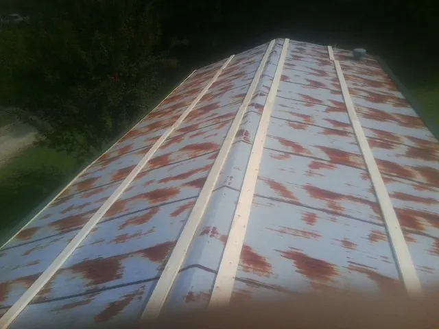 Rusted metal roof panels with new wood purlins before replacement — Storm Damage Roof Repair in Middleton by Roofing Brothers